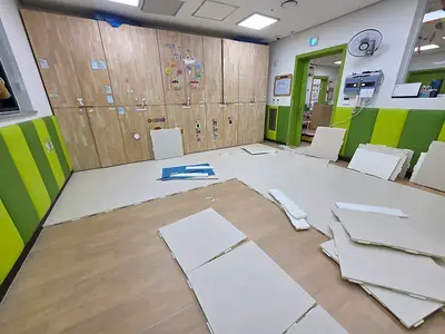 어린이집 교실에 매트를 펼쳐 재단하는 중